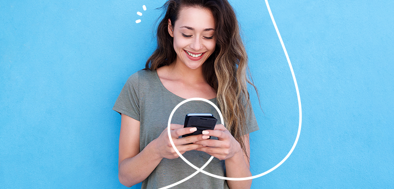 happy customer. smiling woman on blue background holding a mobile